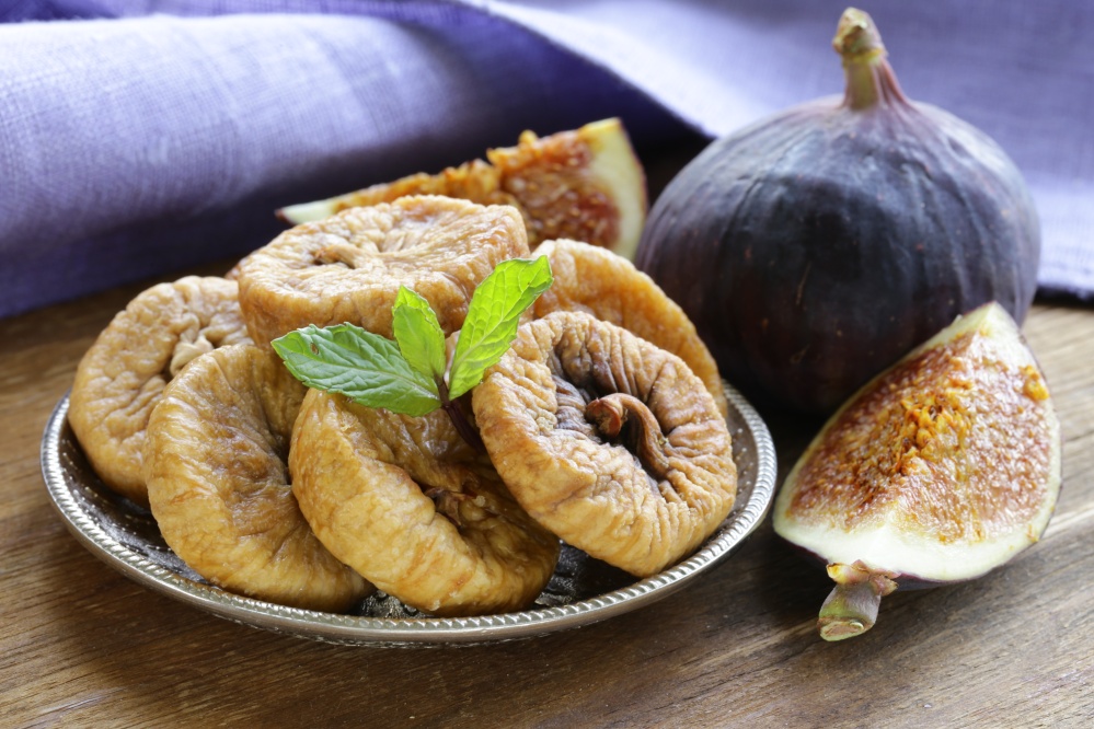 dried figs and fresh fruit on a wooden table